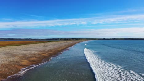 Drone-bird's-eye-view-flying-over-Tramore-Beach,-Ireland-during-the-day