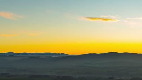 Panning-time-lapse-of-Snezka,-Karkonosze-mountains,-during-a-foggy-yellow-sunset