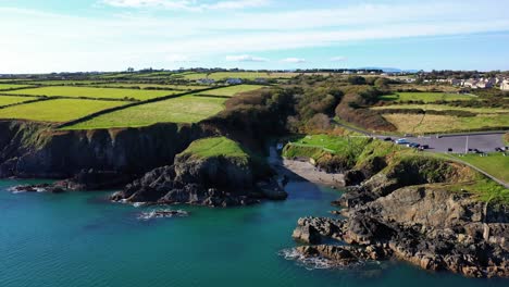 Aerial-flying-in-Newtown-Cove-Swimming-Beach-in-Waterford,-Ireland-on-sunny-day