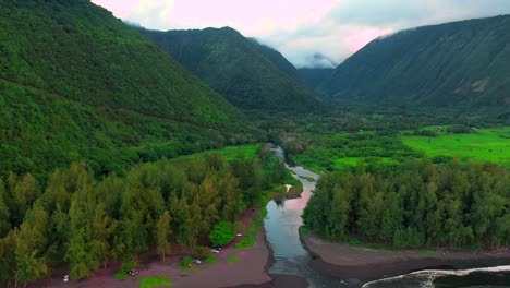 Cinematic-aerial-shot-of-spectacular-Waipio-valley-and-sunset-reflecting-on-Wailoa-stream,-Hawaii
