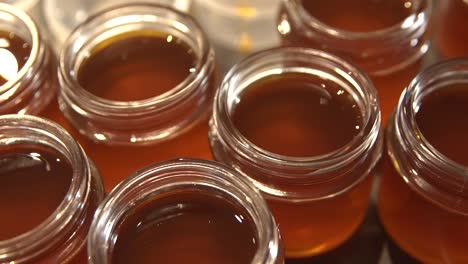Hot-cannabis-salve-oil-stored-in-many-small-containers,-high-angle