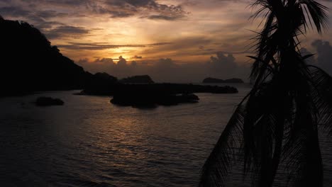 Farbenfroher-Orangefarbener-Sonnenuntergang-über-Panama-Beach-Islands-Silhouette-Dolly-An-Palmen-Vorbei