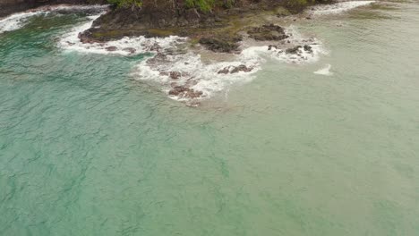 Aerial-push-in-above-tropical-Panama-island-palm-tree-coastline---breaking-waves-on-turquoise-coral-reef
