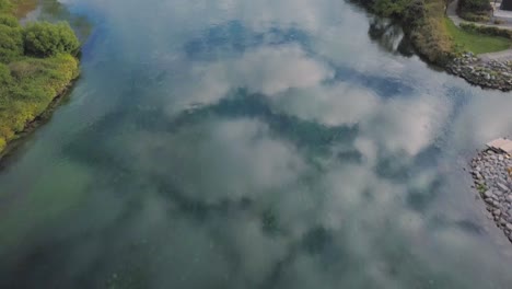Aerial-view-of-clouds-reflecting-in-the-Waikato-River-in-Taupo,-New-Zealand