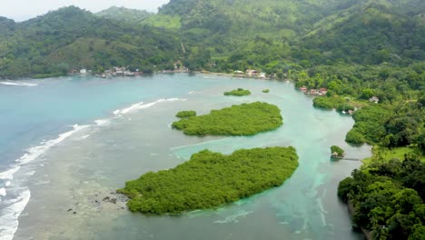 Coastal-Panama-island-turquoise-bay-tilt-up-aerial-view-to-tropical-jungle-mountains