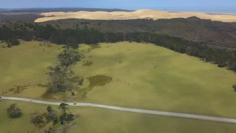 Aerial-wide-shot-of-the-Giant-Sand-Dunes-and-road-at-Te-Paki,-New-Zealand
