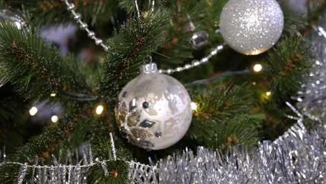 Christmas-tree-decorated-with-lights,-silver-garlands-and-balls
