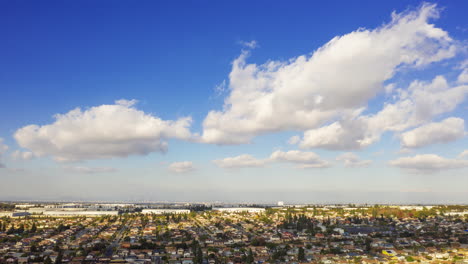 Beautiful-white,-fluffy-clouds-forming-and-fading-over-a-city---Hyper-lapse