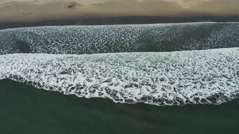 Birds-eye-view-of-Waves-crashing-onto-beach,-Bodega-Bay,-California,-USA