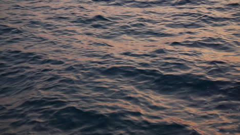 The-Gentle-Waves-Of-The-Ocean-Underneath-The-Silhouette-Of-A-Morning-Sun---Close-Up-Shot
