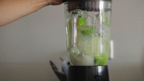 Woman-hands-making-a-fresh-lemonade-with-a-blender