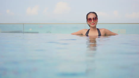 An-attractive-woman-chest-deep-in-a-swimming-pool-relaxes-t-in-its-water