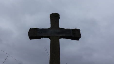 Time-lapse-of-grey-and-dark-clouds-passing-over-old-gravestone---zoom-out
