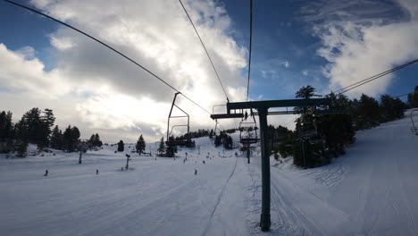 Riding-Ski-Lift-or-Chairlift-Up-Snowy-Winter-Mountain-with-Blue-Sky