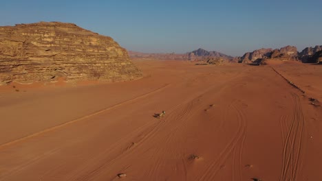 Riding-camels-through-desert-in-Wadi-Rum,-Jordan,-aerial-view