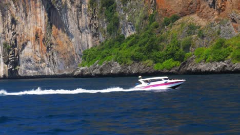 Phi-Phi-Island-In-Phuket,-Thailand---Schnellboot,-Das-über-Den-Inselstrand-Fährt-Und-Die-Natürliche-Schönheit-Der-Kalksteinfelsen-Entdeckt---Breite-Aufnahme