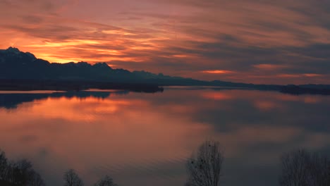 Anamorphes-4k-Luftdrohnenvideo-Eines-Wunderschönen-Sonnenuntergangs-Mit-Roten-Wolken-Am-Idyllischen-Und-Malerischen-Bayerischen-Chiemsee-In-Süddeutschland