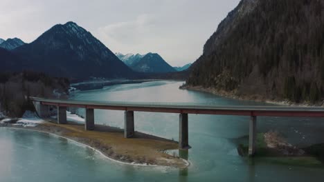 Anamorphic-4K-Aerial-Drone-footage-of-the-scenic-bridge-across-the-Bavarian-water-reserve-lake-Sylvenstein-in-southern-Germany-in-the-alps-mountains