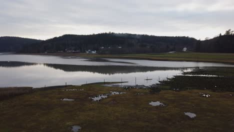 Pan-left-across-quiet-morning-lake-in-Swedish-lowland-of-Bohuslan