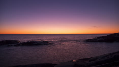 Time-lapse-shot-of-dawn-above-the-Skagerrak-sea-and-the-bare-coast-of-Justoya-island,-sunny-morning,-in-Aust-Agder,-Norway