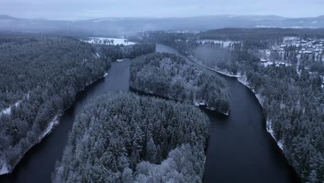 Pull-back-aerial-river-divides-and-unites-around-two-small-islands,-Winter-Landscape