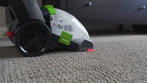 Household-carpet-cleaning-machine-working-to-clean-up-dirt-and-stains-deep-from-within-carpet