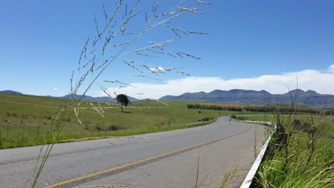 R711-road-outside-Clarens-town-in-Free-state-province-South-Africa-with-cars-and-motorbike-traffic-traveling-past-on-vacation-in-Moluti-Mountains