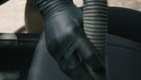 Nahaufnahme-Eines-Mannes,-Der-Schwarze-Handschuhe-Trägt,-Saugt-Ein-Schwarzes-Innenauto