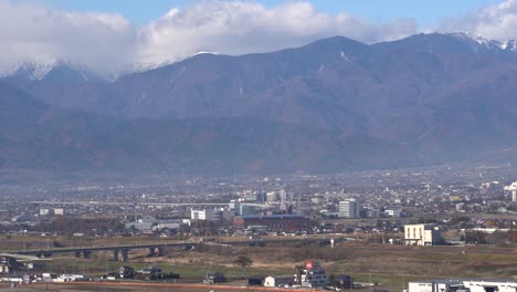 Wide-open-view-of-Yamanashi-Prefecture-Landscape-with-cars-driving-and-mountain-backdrop