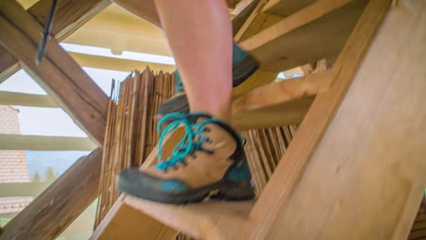 Close-up-shot-of-the-feet-of-a-female-hiker-walking-downstairs-in-a-wooden-building