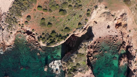 Luftbild:-Überfliegen-Der-Felsigen-Küste-Der-Portugiesischen-Algarve-Mit-Klarem-Wasser