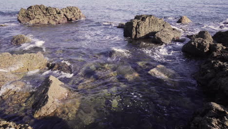 Blaues-Wasser-Bewegt-Sich-Um-Einige-Felsen-In-Der-Algarve-Portugal