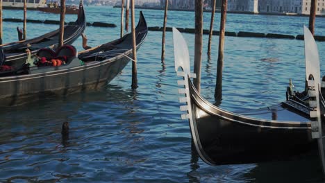 Medieval-Gondola-Docked-in-Major-Busy-Venice-Canal