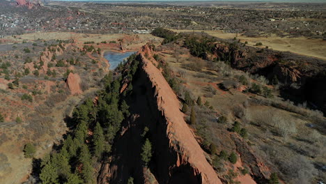 Revealing-drone-footage-of-Rock-formations-and-a-frozen-pond,-over-Red-Rock-Canyon-open-space-in-Colorado-Springs,-Colorado
