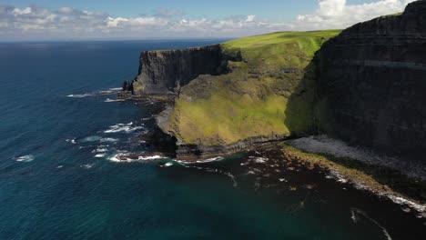 Cliffs-of-Moher-collapsed-cliff-from-coastal-erosion,-aerial-pull-back