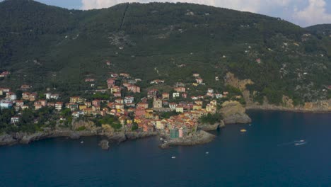 Fast-pull-in-reveal-shot-of-colorful-Tellaro-fishing-village,-coast-line-and-the-vineyards