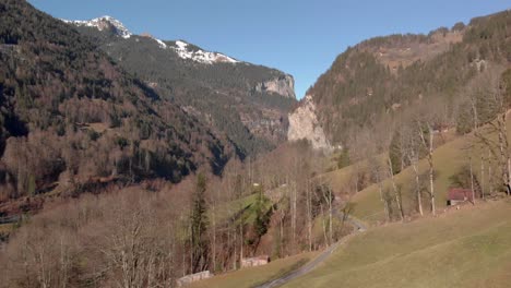 Vista-Aérea-De-Una-Cabaña-De-Montaña-En-Primer-Plano-Y-Un-Pintoresco-Valle-En-El-Fondo,-Lauterbrunnen,-Suiza