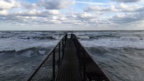 Dark-metal-pier-in-leading-into-the-ocean