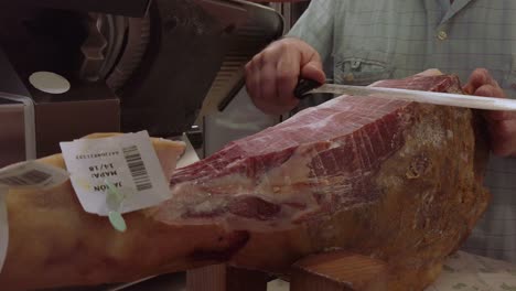 Man-Slicing-Typical-Jamon-Iberico-Leg-of-Ham-with-Sharp-Knife-in-Spain