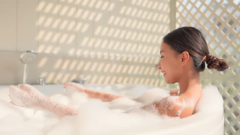 Attractive-Asian-Girl-Playing-with-Foam-when-Enjoying-a-Relaxing-Bath