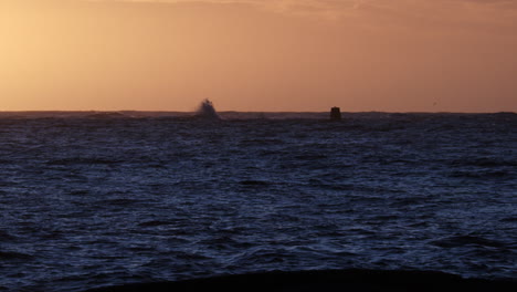 Slow-motion-shot-of-waves-hitting-rocks,-on-the-Skagerrak-sea,-at-dawn,-in-Justoya,-Aust-Agder,-Norway