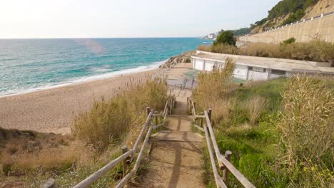 san-pol-,-maresme-beach,-barcelona,-mediterranean-coast,-calm-sea-sand-and-rocks