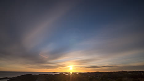 Time-lapse-shot-of-sunset-above-a-rocky-coast-and-the-Skagerrak-sea,-on-Justoya-island,-sunny-evening,-in-Aust-Agder,-Norway