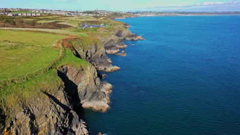 Aerial-flying-of-Newtown-Cove-in-Waterford,-Ireland-on-bright-day