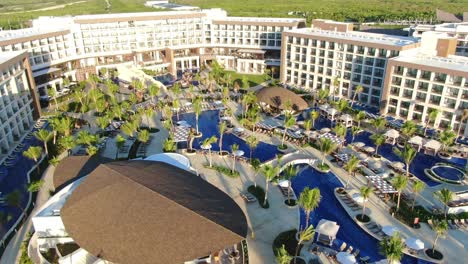Swimming-pool-area-in-luxury-vacation-all-inclusive-resort,-aerial-view-of-poolside-in-exclusive-hotel,-sunchairs-and-lounges-and-pool-bar,-Caribbean-getaway,-romantic-lifestyle-and-travel-destination