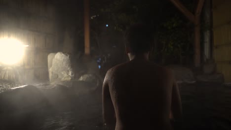 Back-View-of-A-Young-Female-In-Outdoor-Hot-Spring-Bath-in-Japan-During-Nighttime--Close-Up-Shot