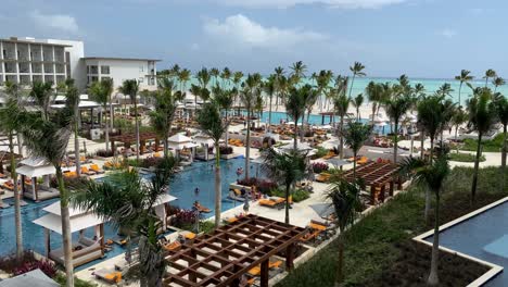 Luxusresort-Mit-Poolbereich,-Menschen,-Unkenntlich,-Schwimmen-Und-Sonnenbaden,-Exklusives-Urlaubsziel,-Kurzurlaub-In-Der-Dominikanischen-Republik,-Reicher-Lebensstil-Und-Tourismus