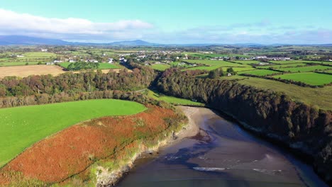 Aerial-dolly-flying-over-coast-in-Waterford,-Ireland-on-sunny-day