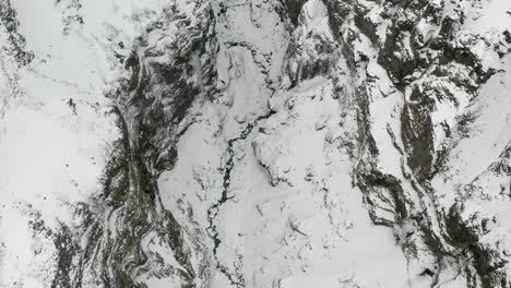 Birds-eye-view-looking-straight-down-on-snowy-frozen-canyon