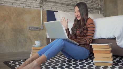 Happy-female-student-video-chatting-on-laptop-computer-Static-Interior